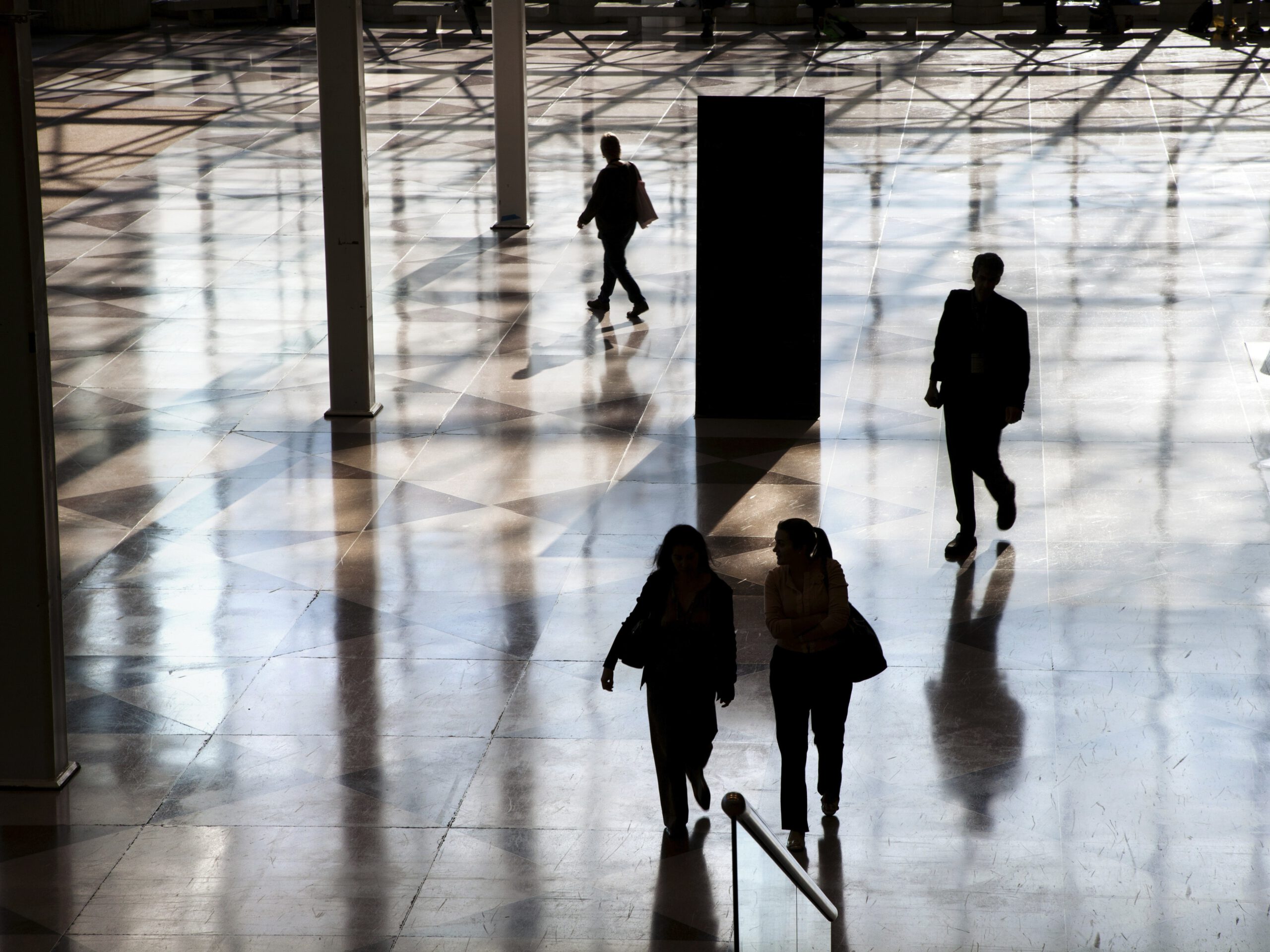 Personas caminando por un vestíbulo de acceso