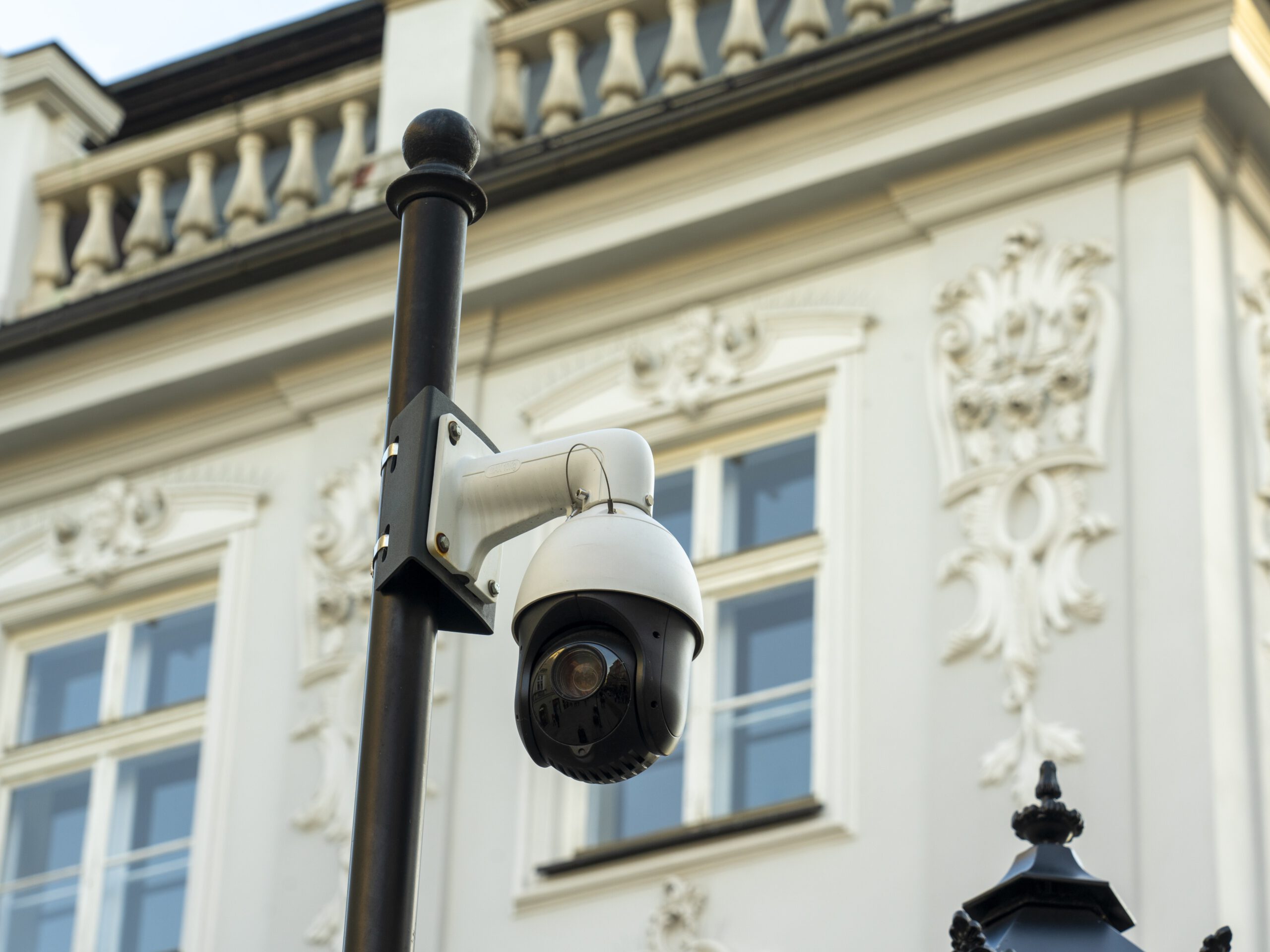 Cámara de videovigilancia en un poste frente a un edificio histórico